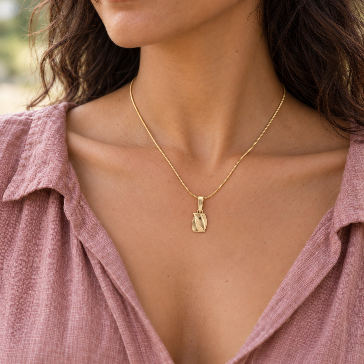 solid 14K yellow gold Twisted Rectangle keepsake pendant worn on an adult model