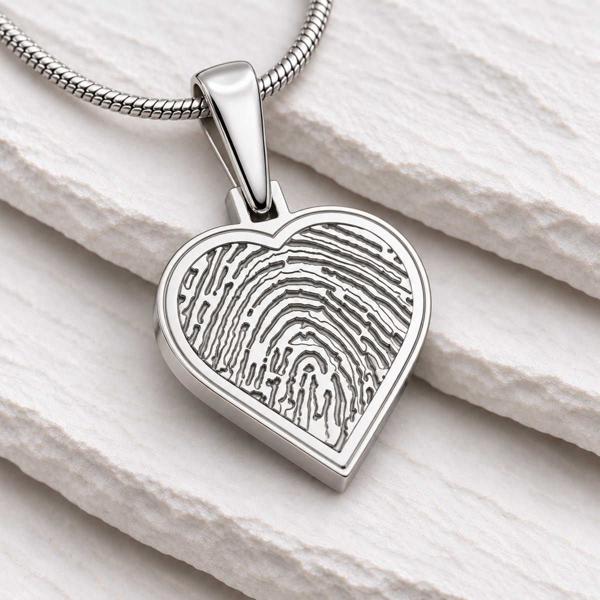 Sterling silver heart fingerprint pendant — close-up on white stacked slate
