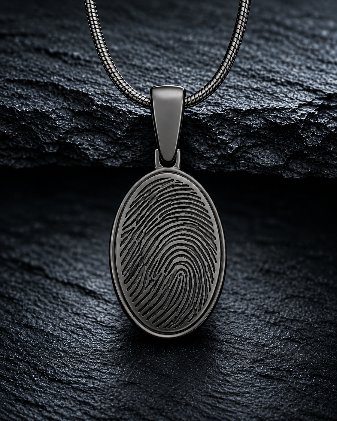 Black-plated oval fingerprint necklace on dramatic charcoal slate