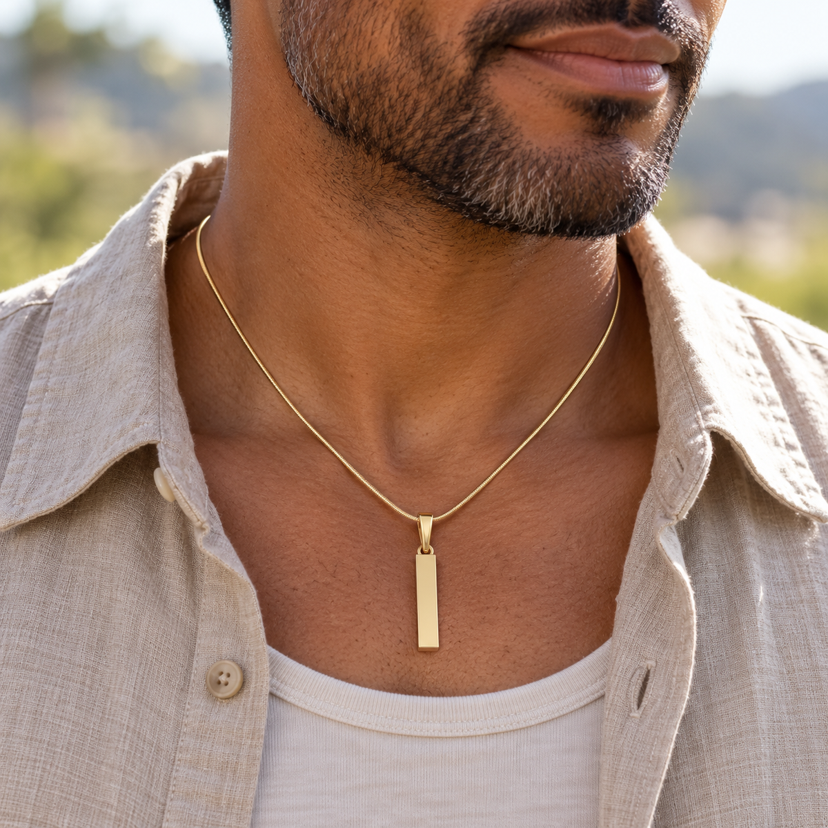 Solid 14K gold Steadfast Long Cylinder pendant worn on a matching gold snake chain