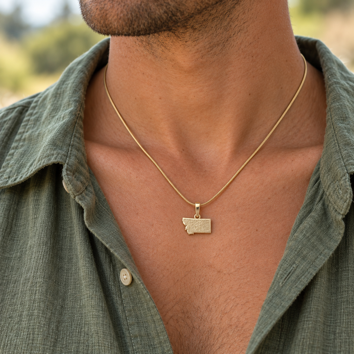 solid 14K yellow gold State keepsake pendant worn on an adult model