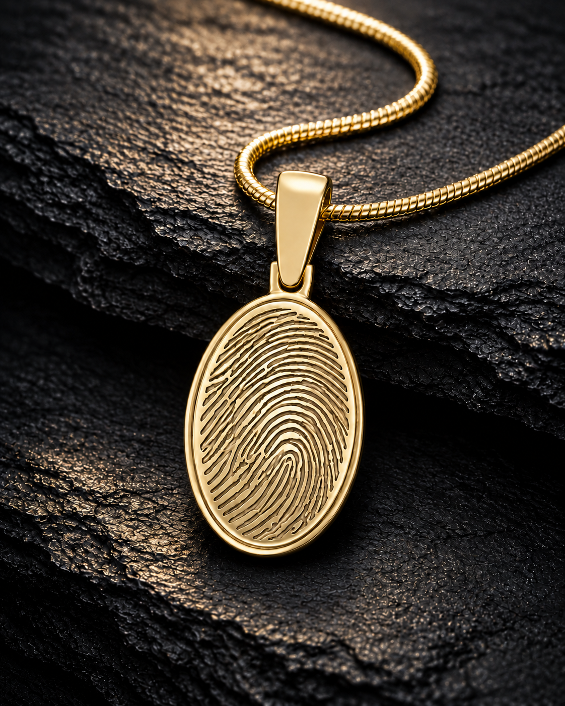 Gold-plated oval fingerprint necklace on dramatic charcoal slate